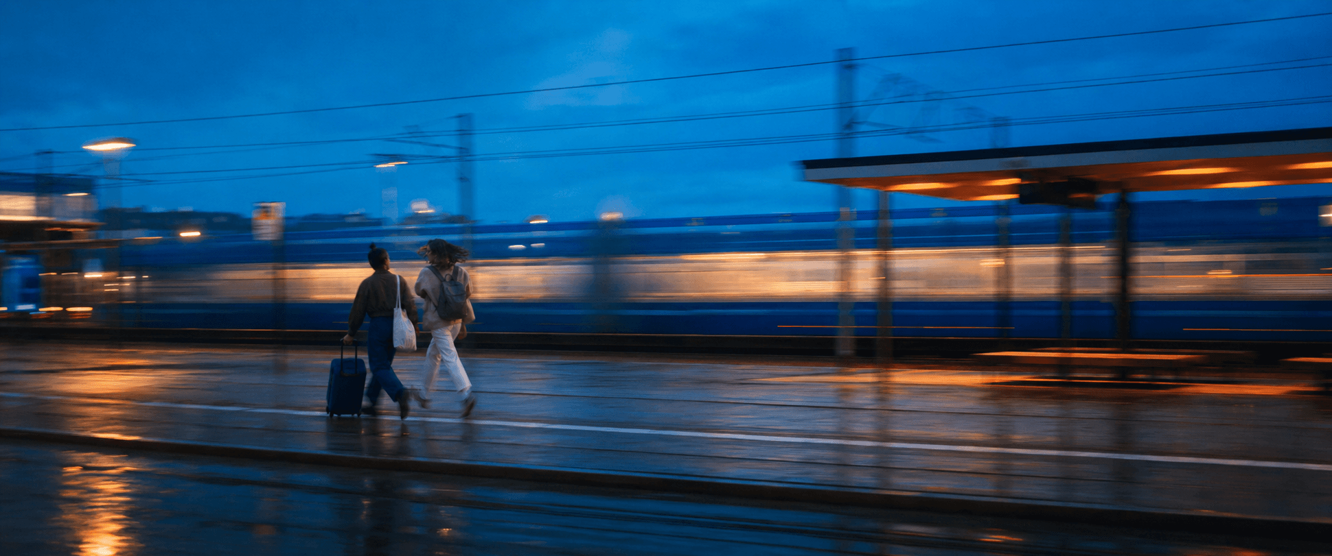 Citymate brand illustration: travellers with a suitcase beside a tram, with lights blurred by motion.